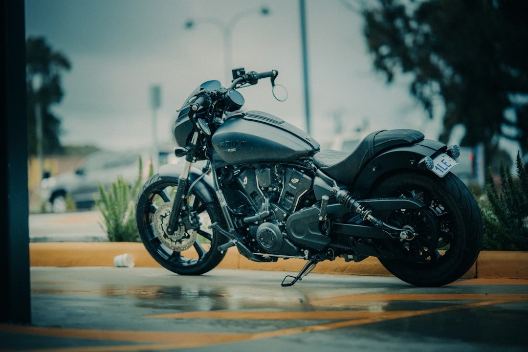 Dark motorcycle parked on wet pavement