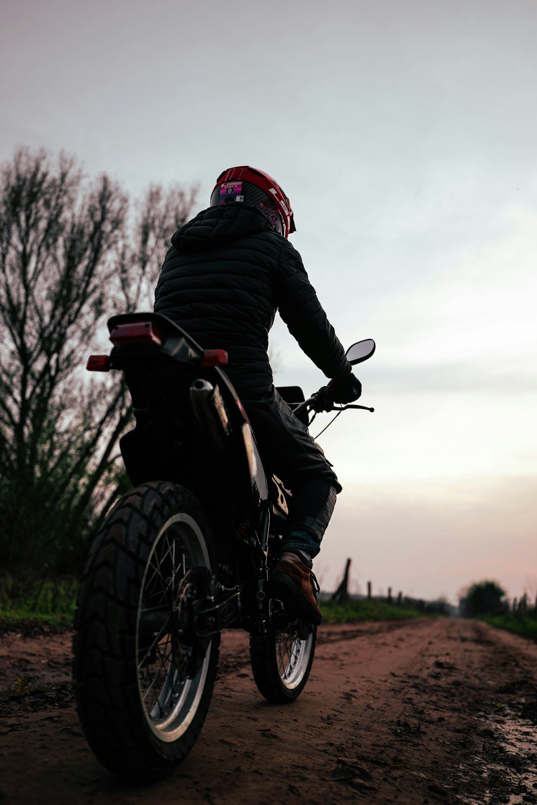 Rider on dirt bike on a rural road at dusk