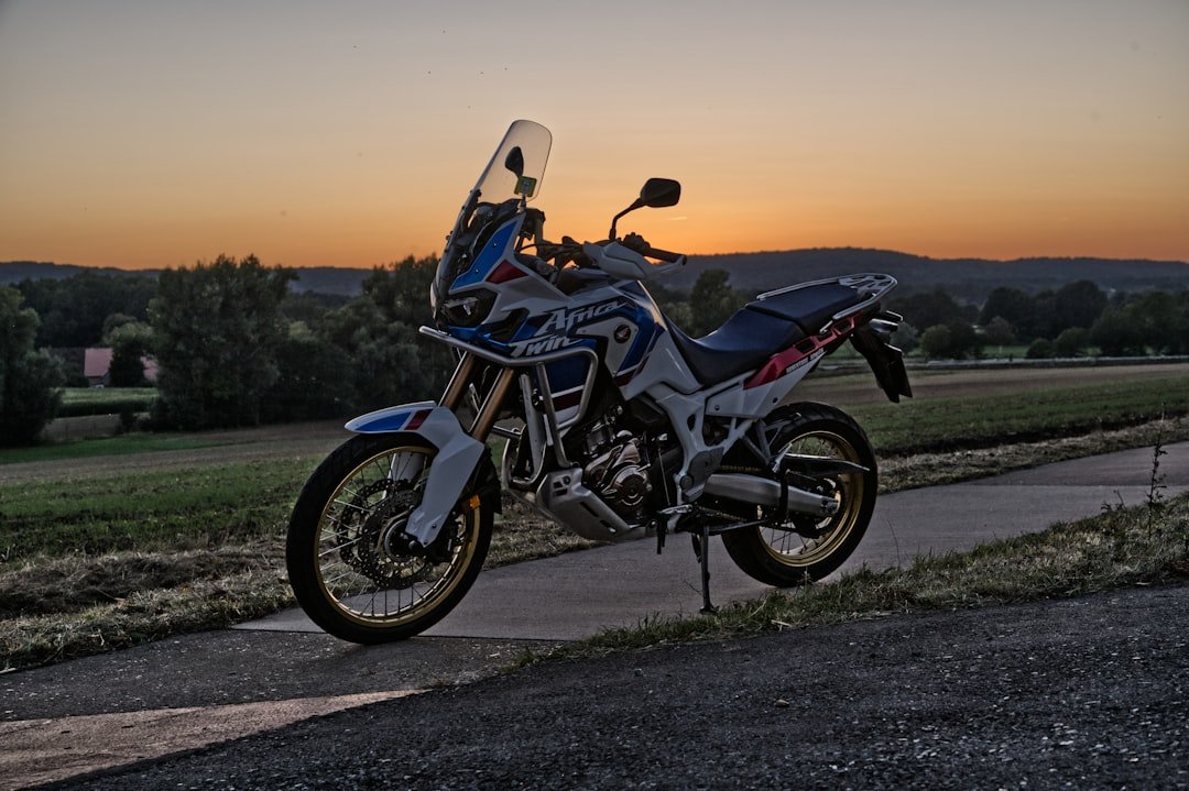Motorcycle parked on a road at sunset