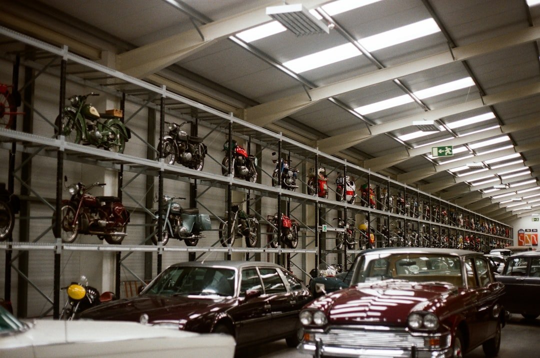 Vintage cars and motorcycles displayed in a large garage.