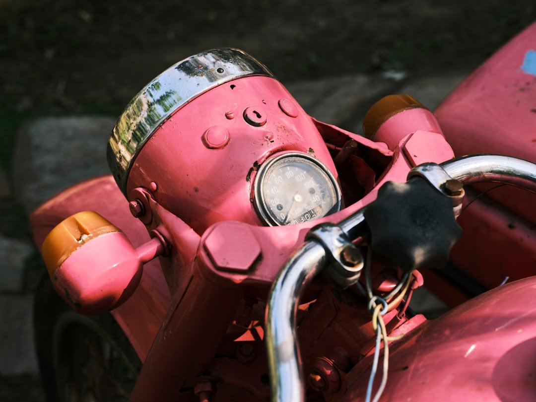 a close up of a pink motor bike