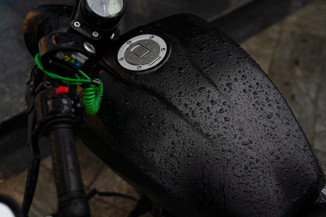 a close up of a motorcycle handlebar with water droplets on it