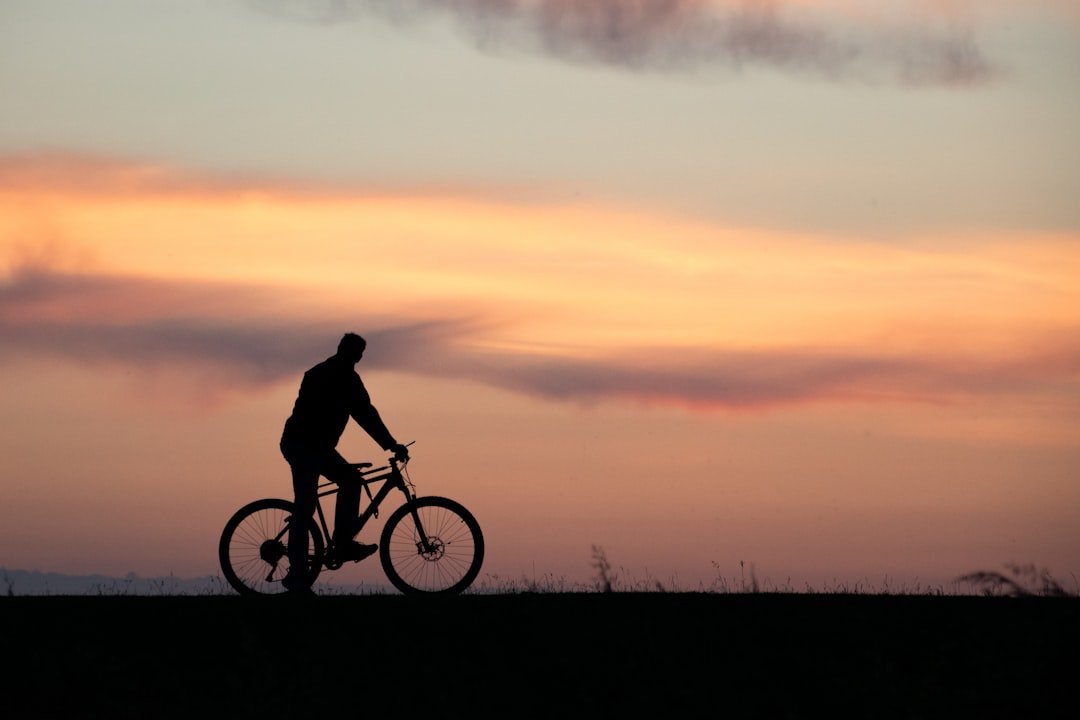 a man riding a bike on top of a grass covered field