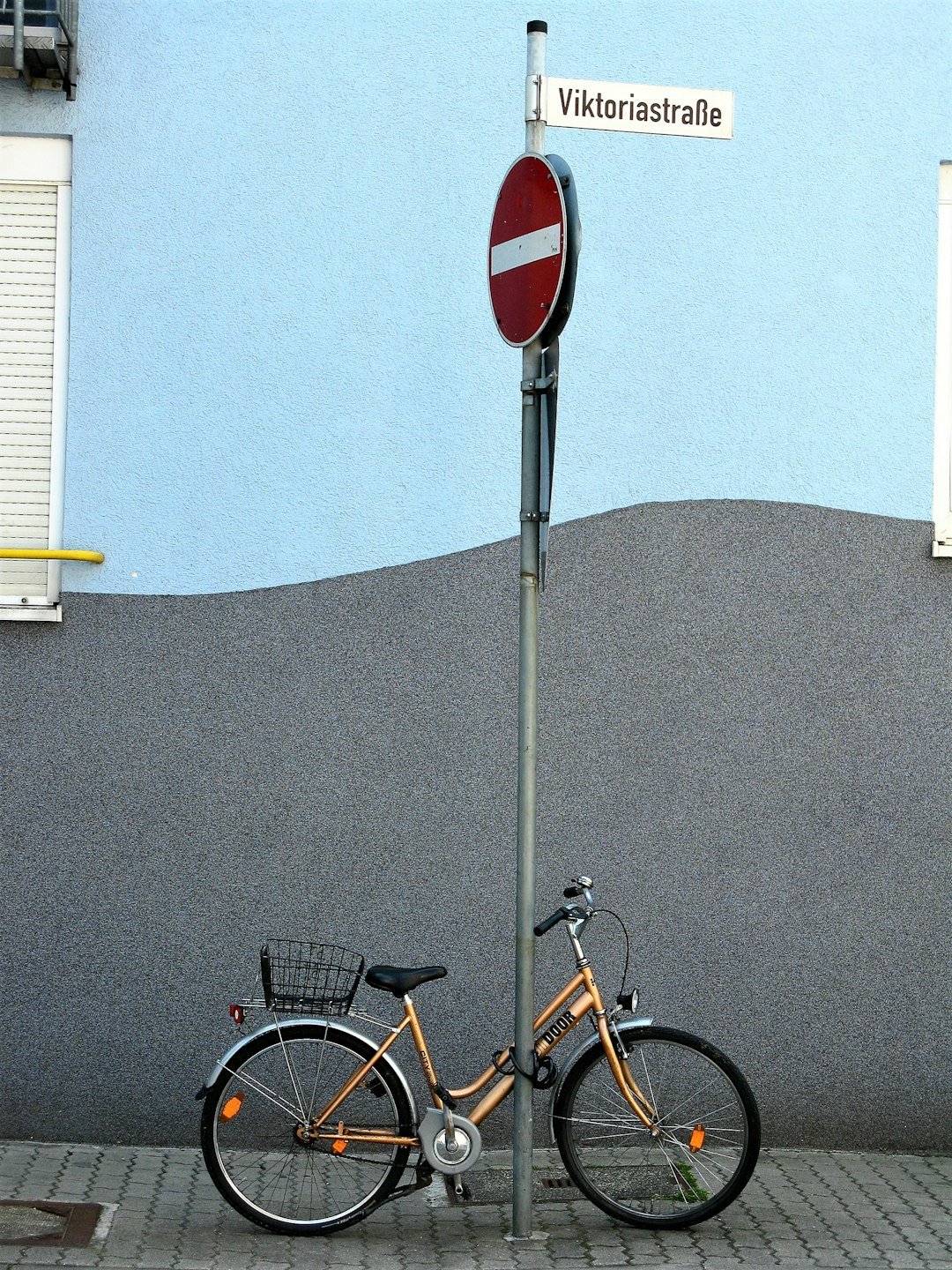 black and yellow city bike parked beside gray concrete wall