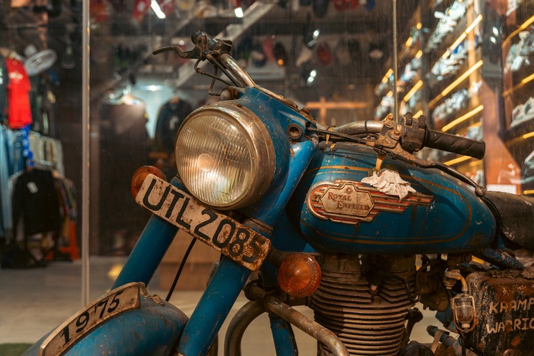 A vintage blue motorcycle with a license plate.