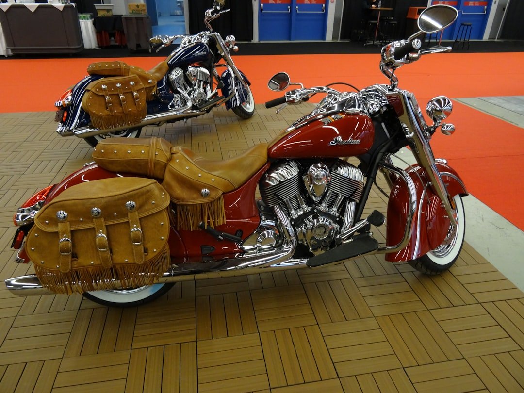 Two classic red motorcycles with leather saddlebags