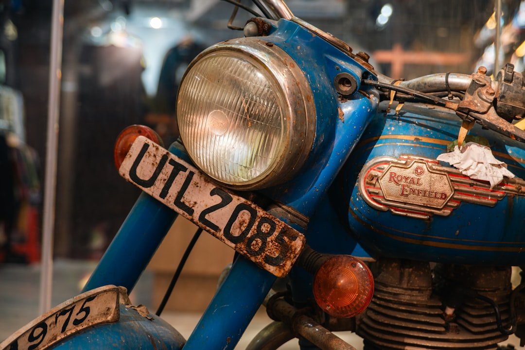 Close-up of a vintage blue motorcycle with license plate.