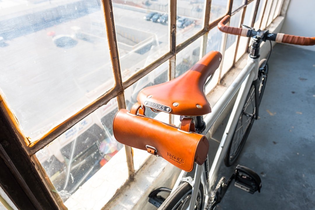 white and orange bike leaning on glass window