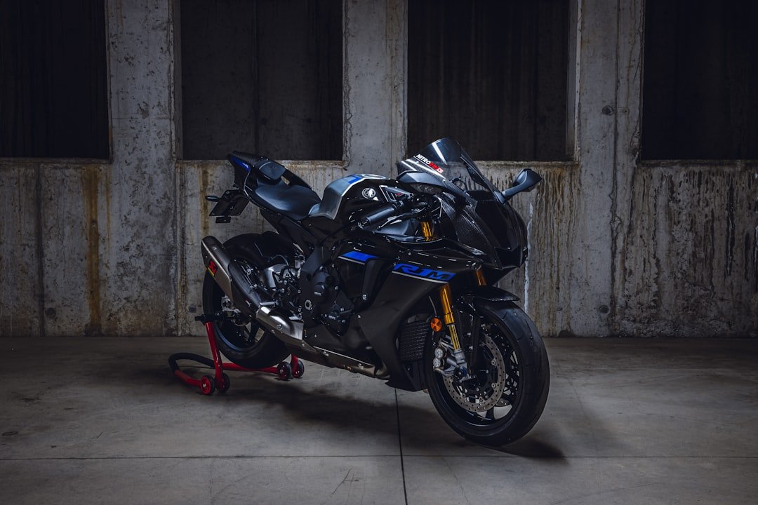A black sport motorcycle on a stand indoors.