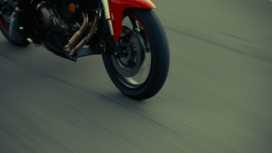 Red motorcycle wheel in motion on asphalt