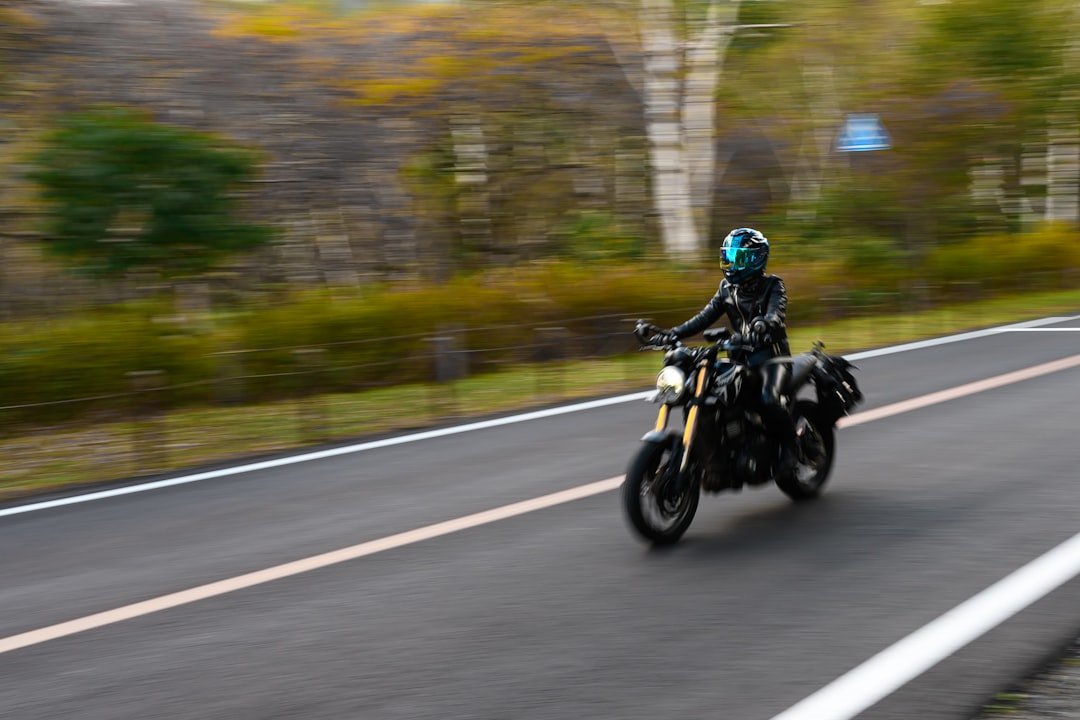 A man riding a motorcycle down a curvy road