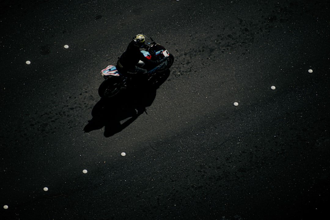 a person riding a motorcycle on a black surface
