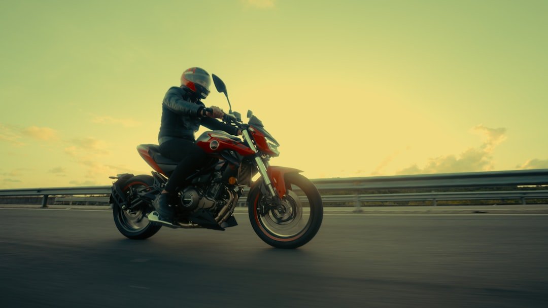 Rider on a red motorcycle on a highway at sunset