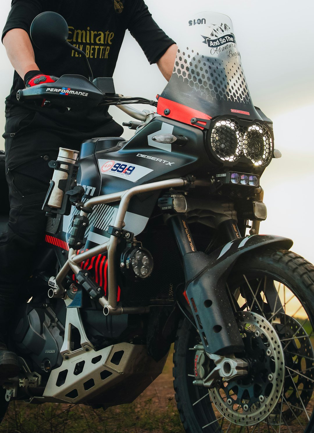 Rider on a custom adventure motorcycle outdoors.