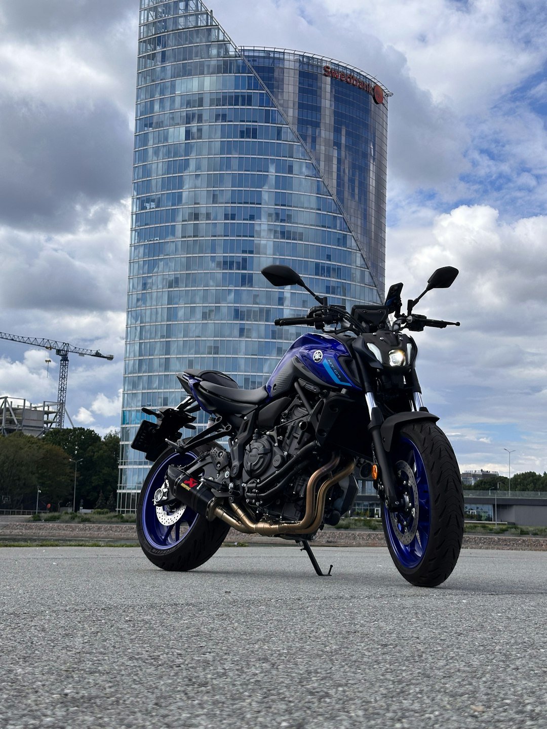 A blue motorcycle parked in front of a tall building