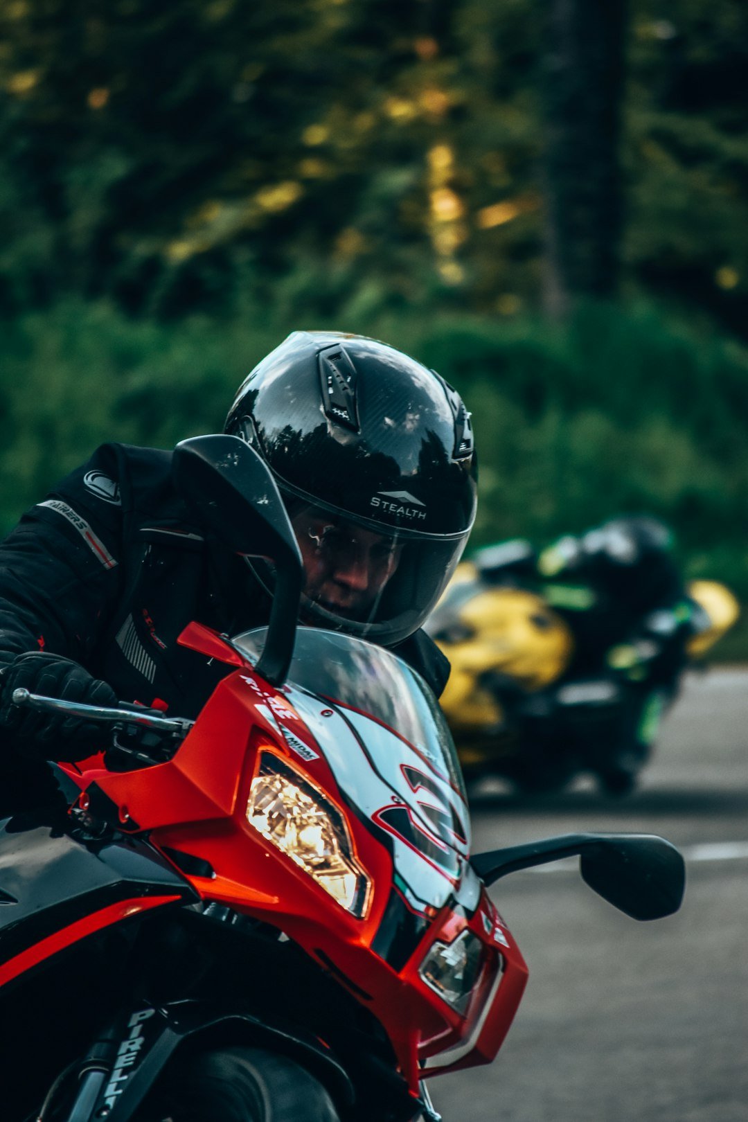 a man riding a red motorcycle down a curvy road
