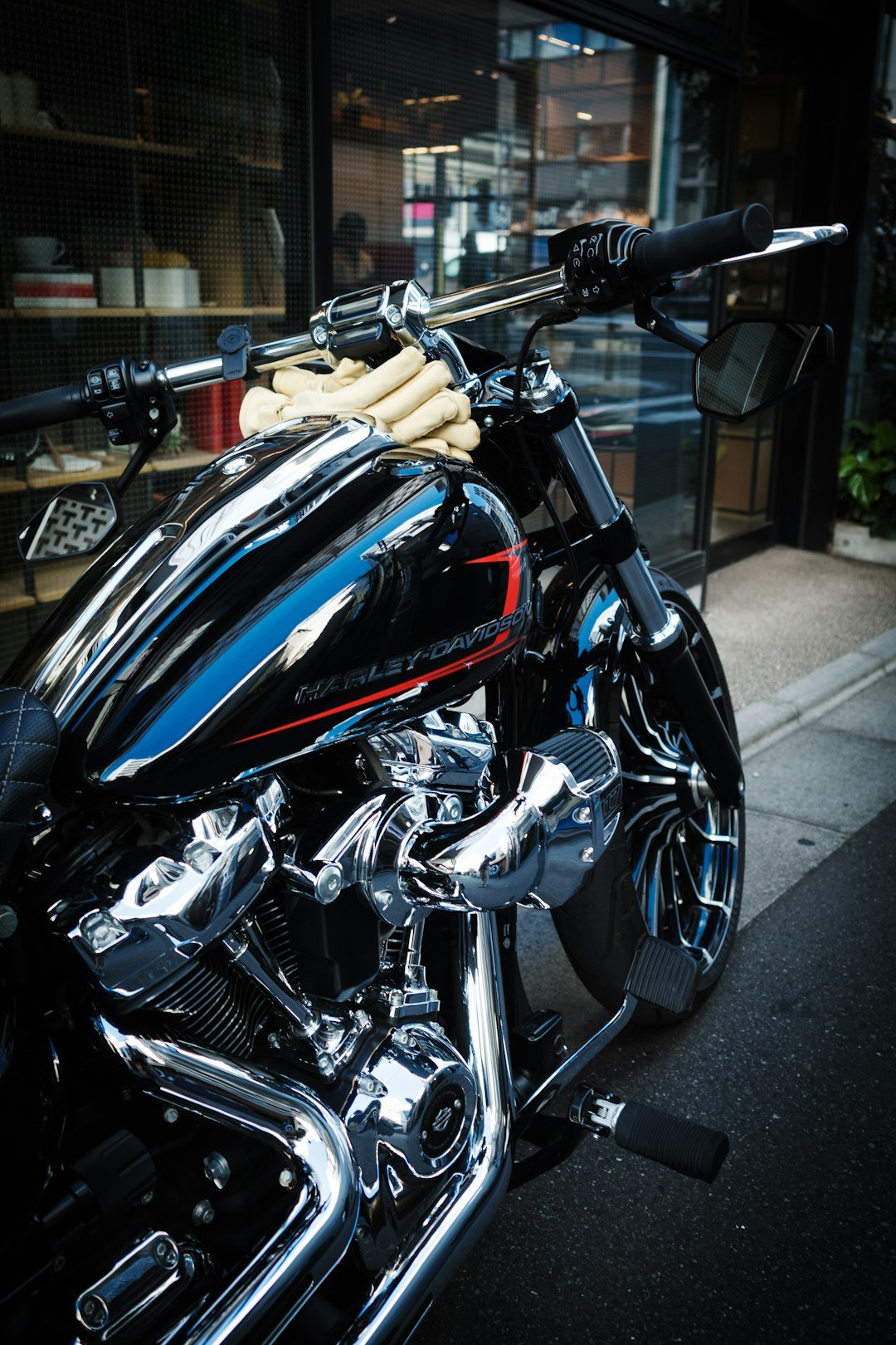 Shiny black harley-davidson motorcycle parked outside.