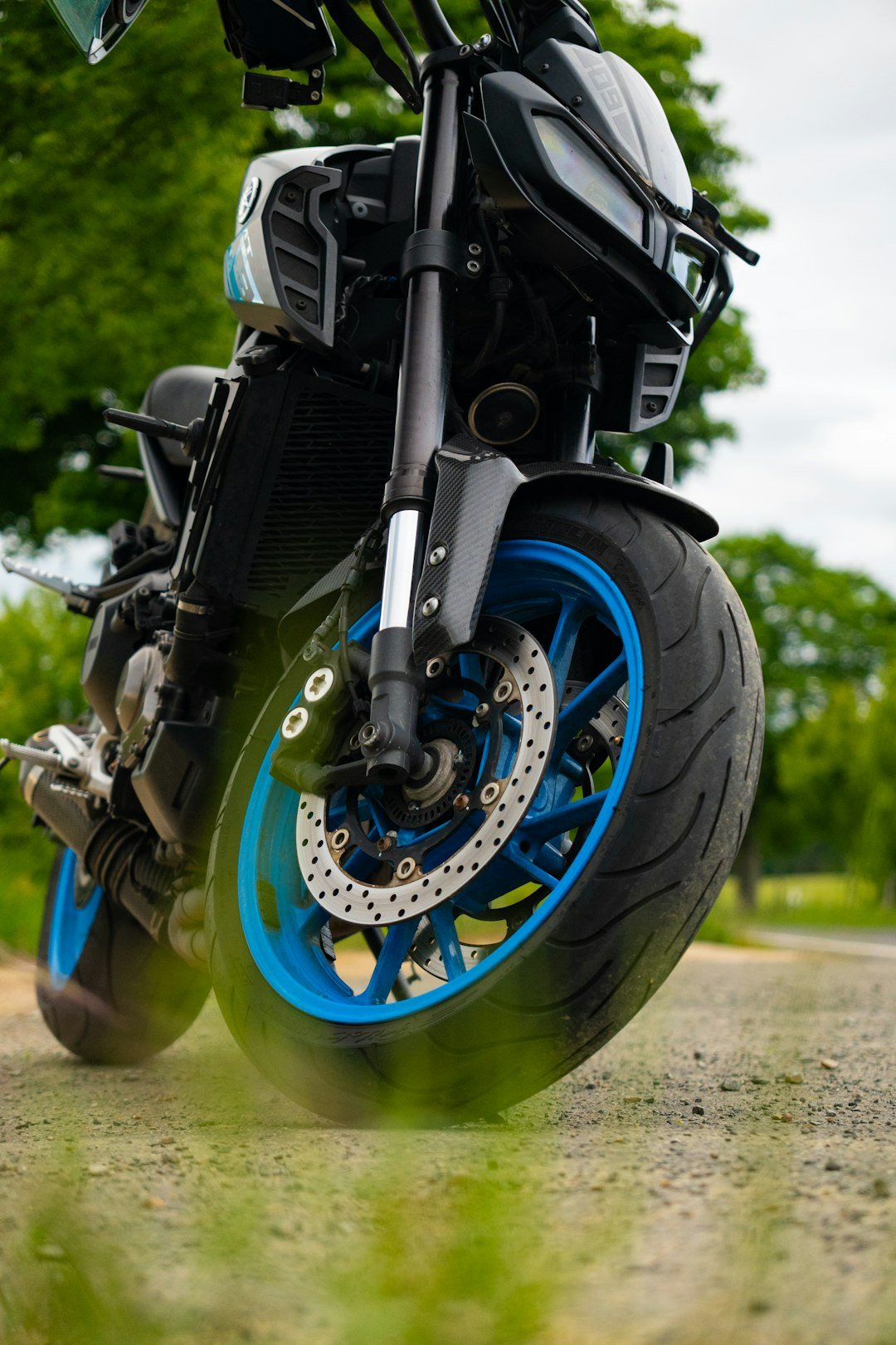 A black motorcycle with bright blue rims.