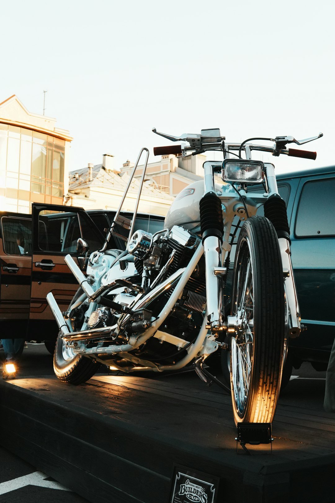 A custom white motorcycle on display outdoors.