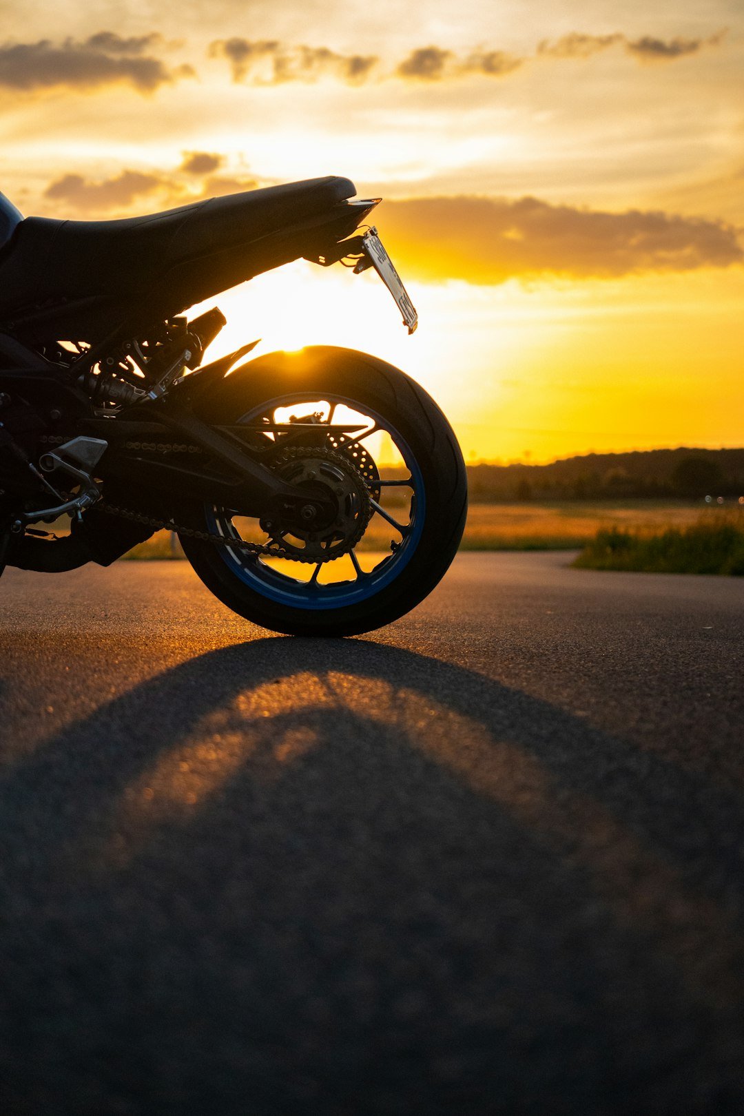 Motorcycle parked on a road at sunset