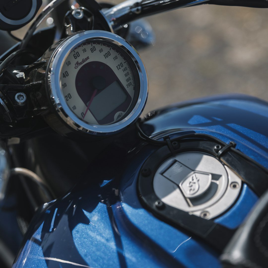 Close-up of a blue motorcycle's dashboard and fuel tank.