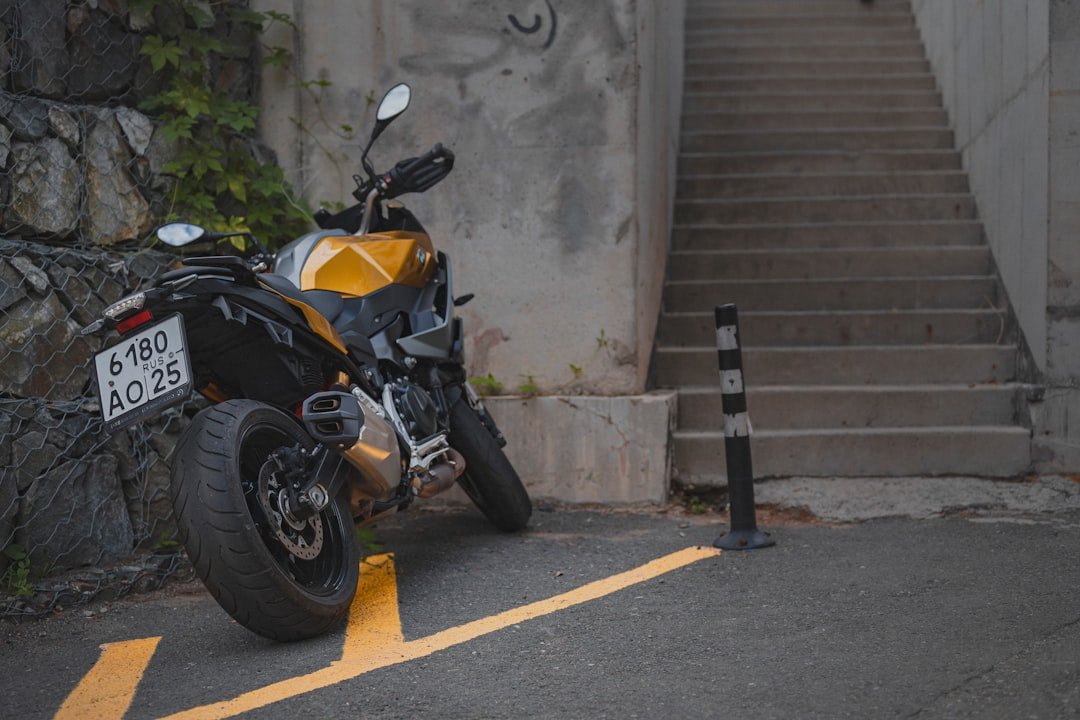 Yellow motorcycle parked next to concrete stairs