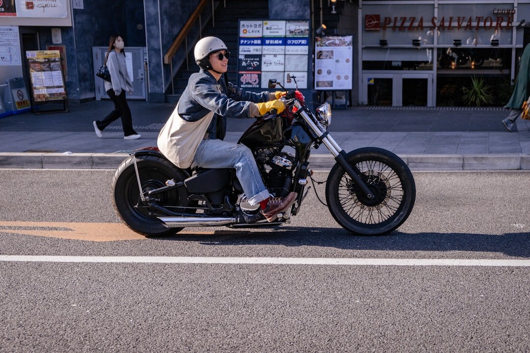 A person rides a motorcycle down a city street.