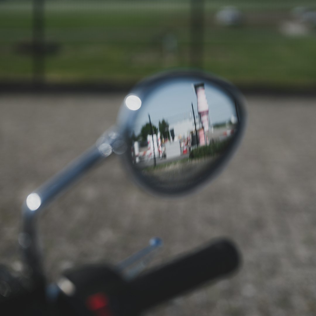 The mirror reflects a building in the distance.