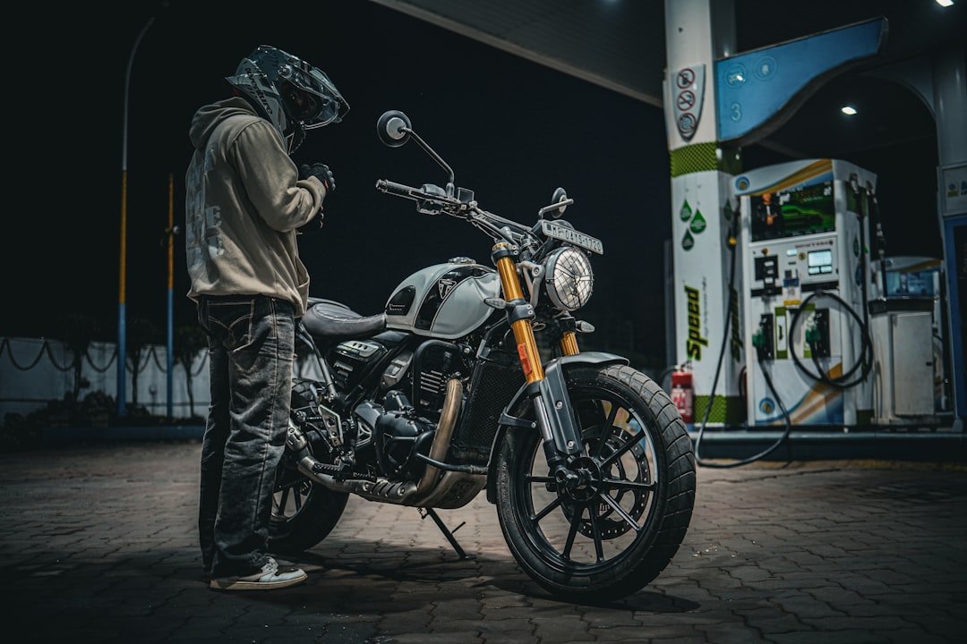 Man in helmet with motorcycle at gas station