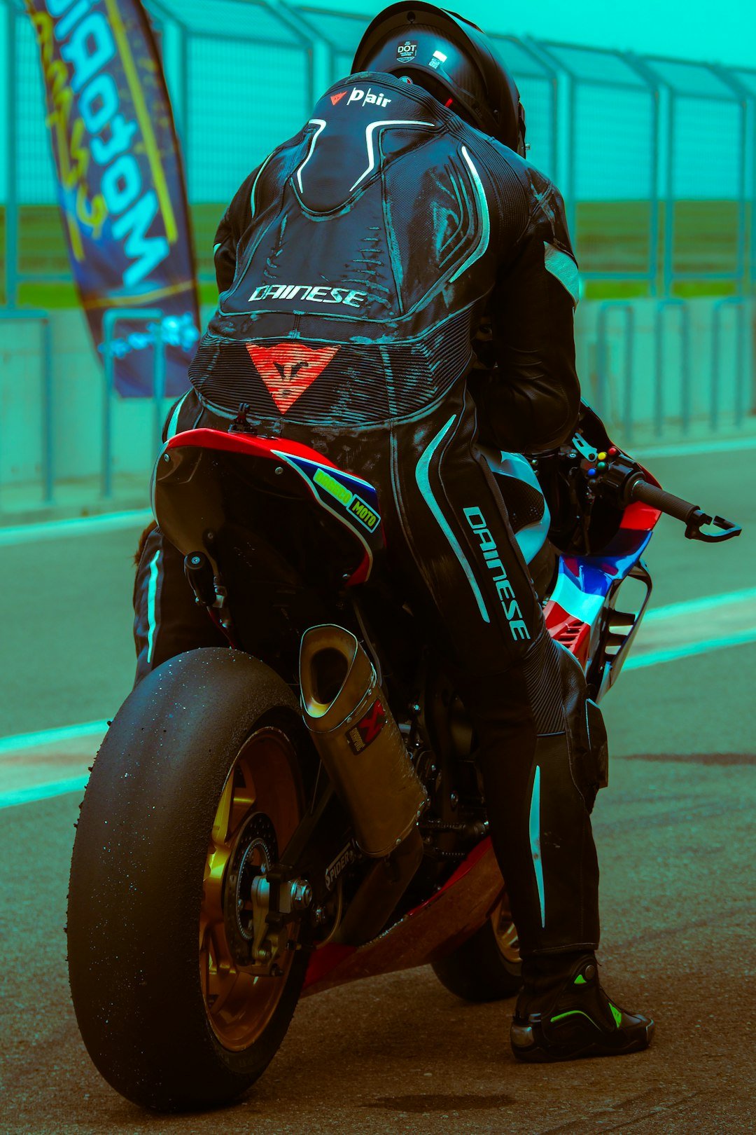 Racer in full gear on a motorcycle at track.