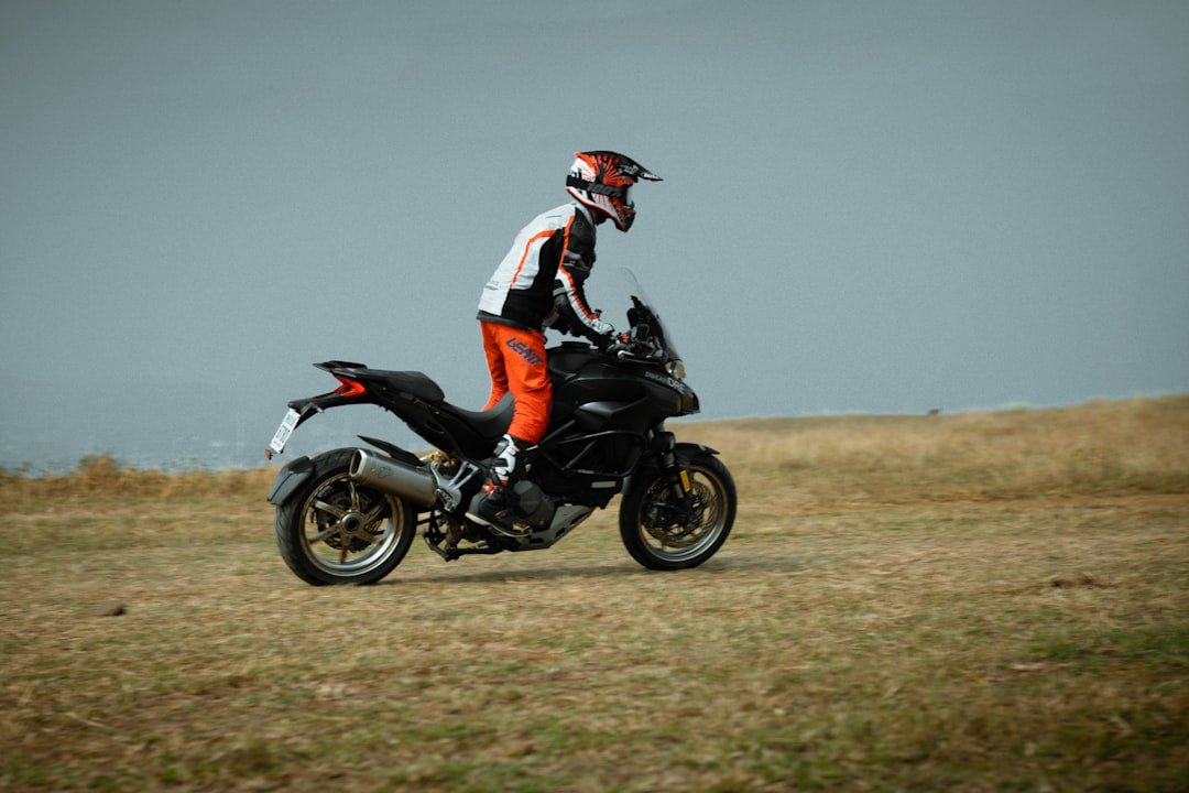 a man riding a motorcycle on top of a grass covered field