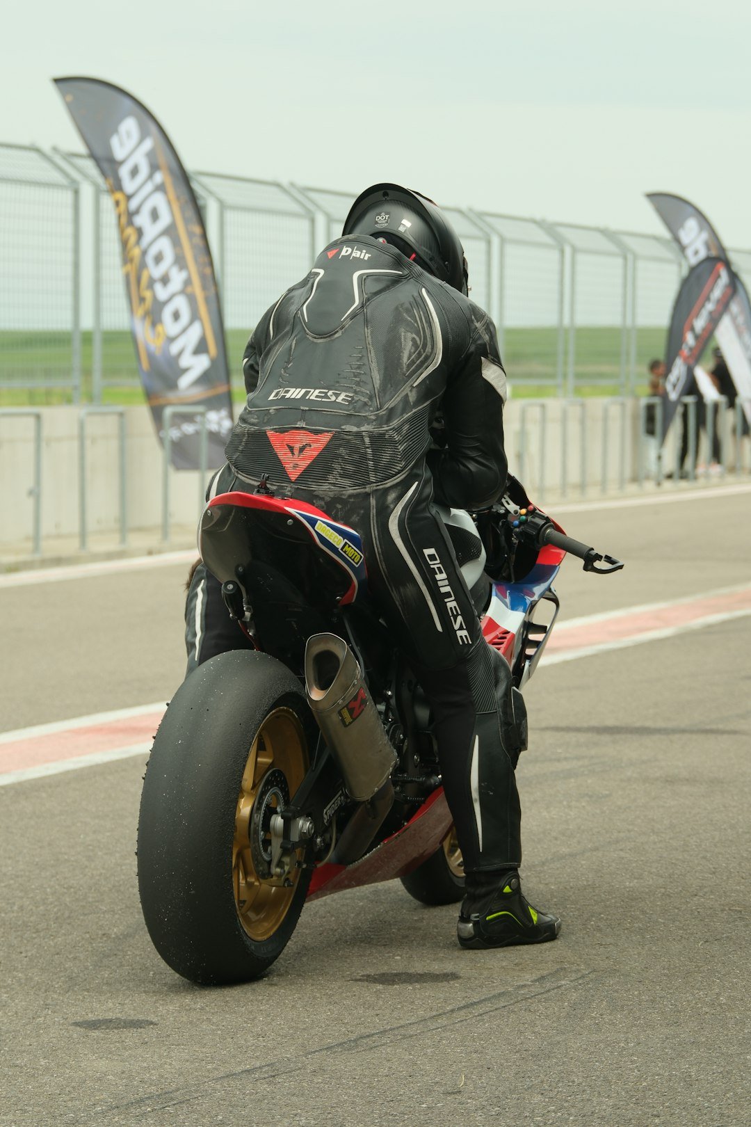 Racer in full gear on a motorcycle at track