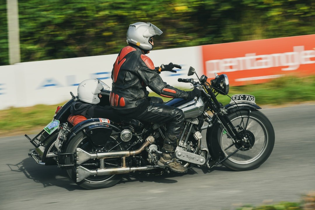 Rider on vintage motorcycle racing on a track.