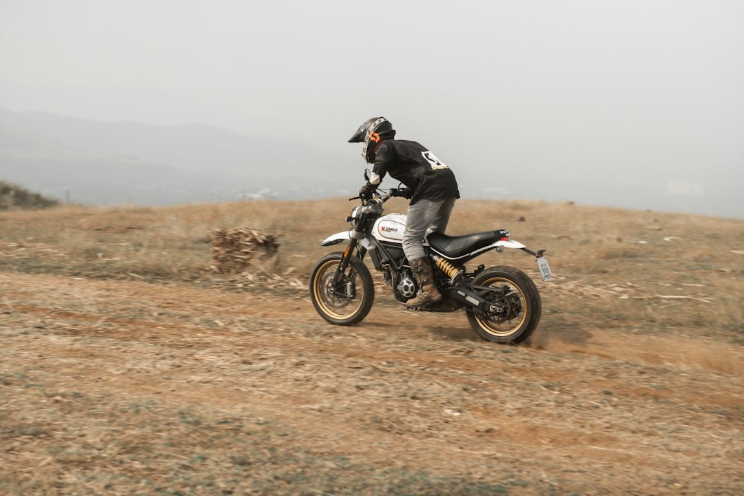a man riding a dirt bike on a dirt road