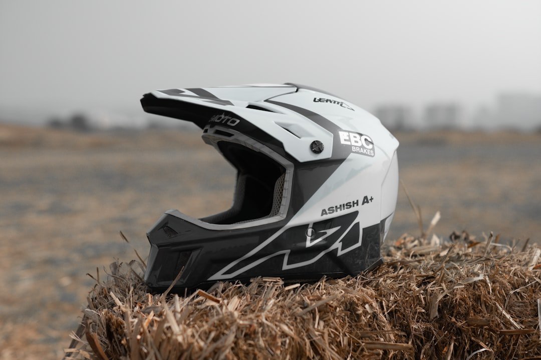 a helmet sitting on top of a pile of dry grass