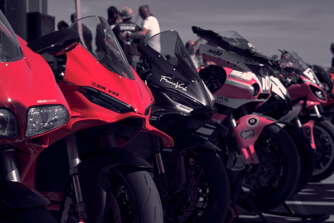 Row of colorful sport motorcycles parked outdoors.