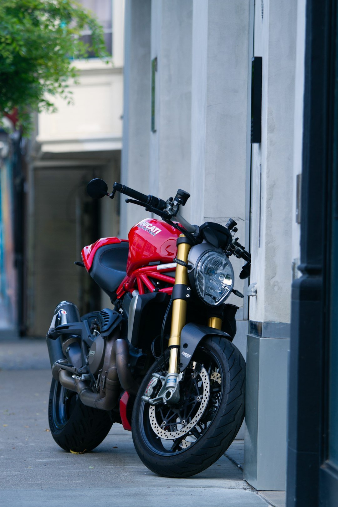 Red ducati motorcycle parked on a city street.