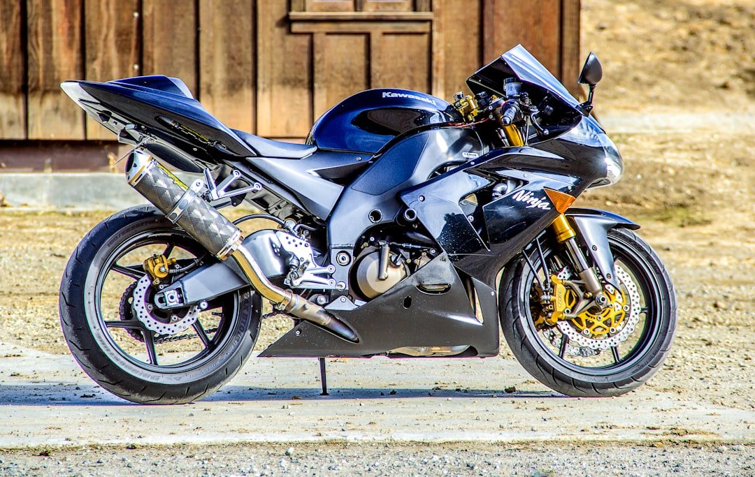 black and silver sports bike parked on gray concrete road during daytime