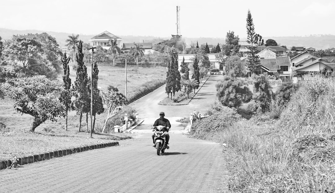 a man riding a motorcycle down a dirt road