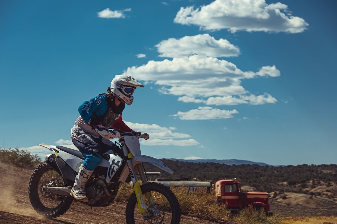 a man riding a dirt bike on a dirt road