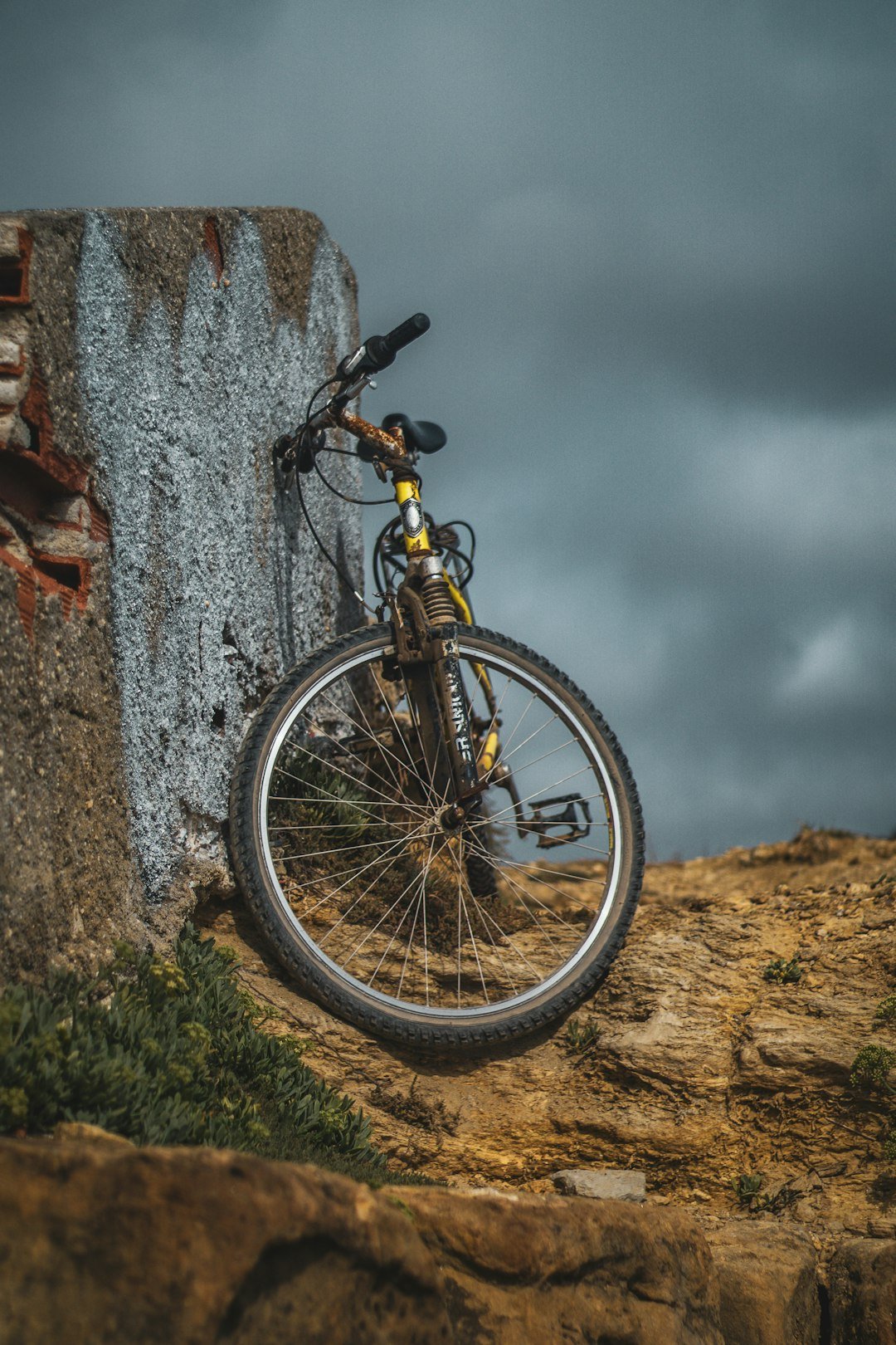 A bike is leaning against a rock wall