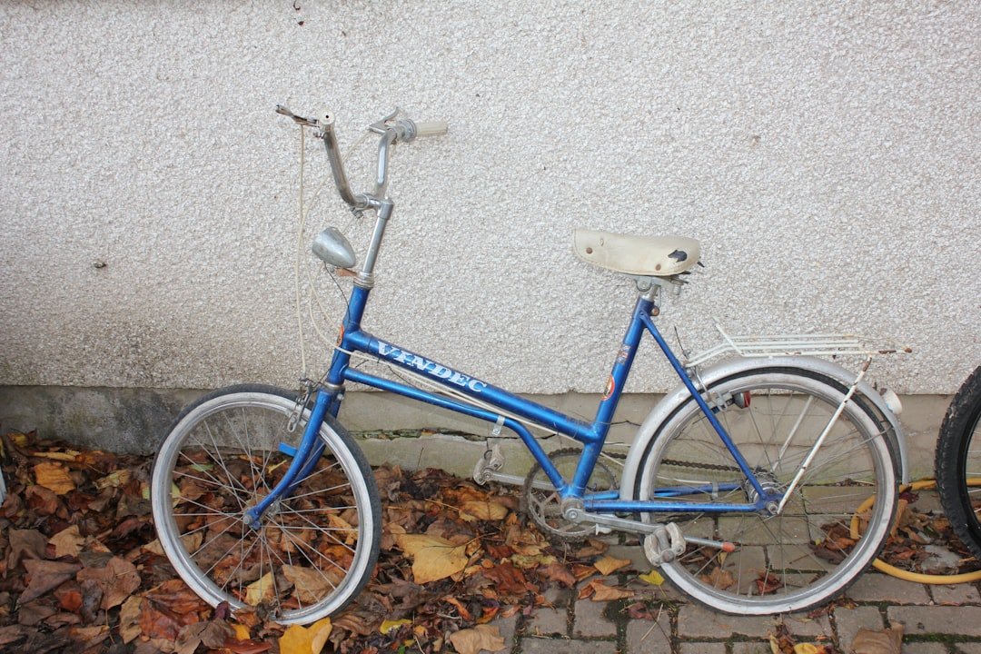 a blue bicycle parked next to a white wall