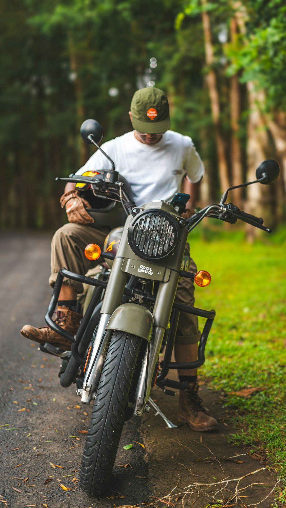 A man sits on a motorcycle on a road.