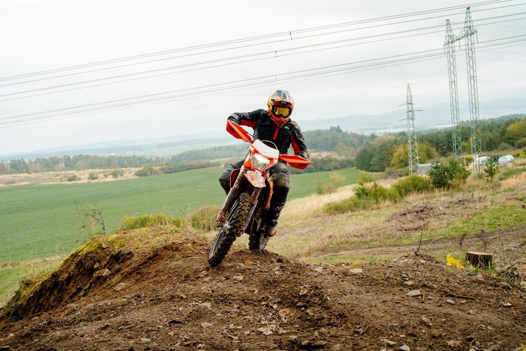 A man riding a dirt bike on top of a dirt hill