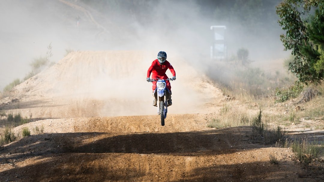 a man riding a bike down a dirt road
