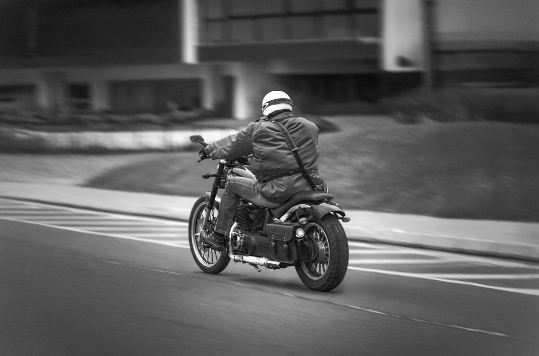 A man riding a motorcycle down a street