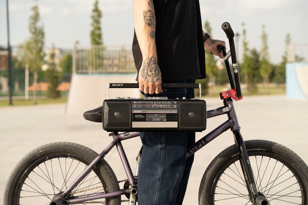 Person holding boombox on bmx bike at skatepark