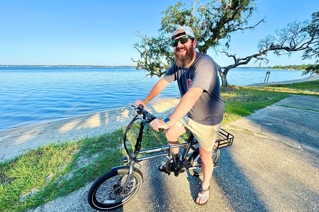 A man riding a bike down a road next to the ocean