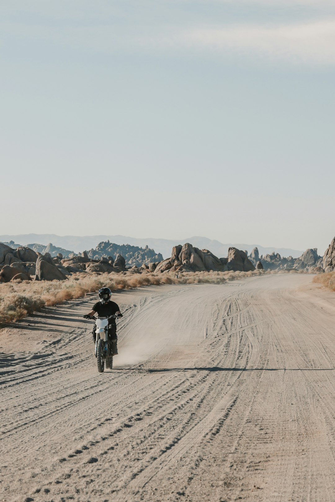 Man riding dirt bike on dusty desert road