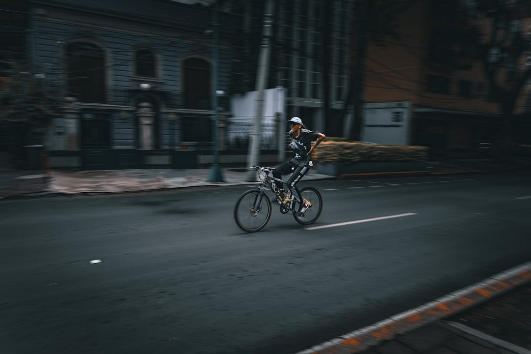 A cyclist rides down a dark city street.